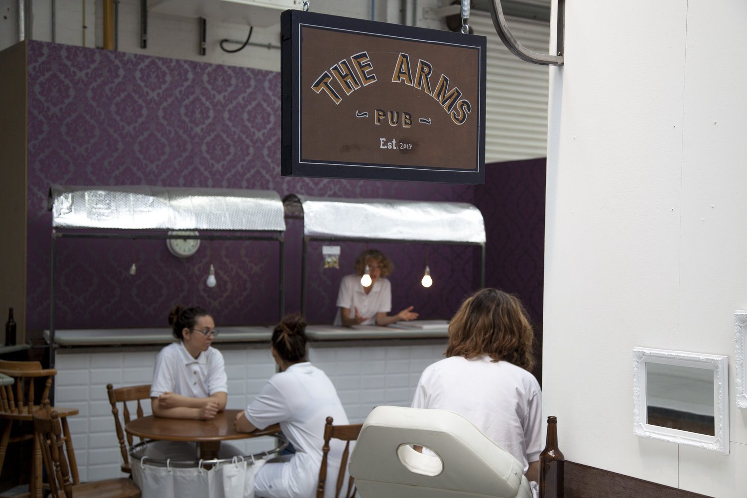 The Arms: a hand-painted pub sign hanging in the gallery